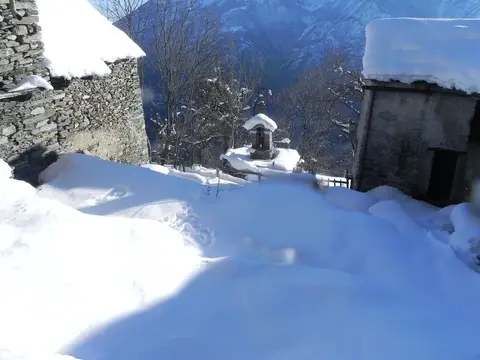 Una fontana tra le baite innevate