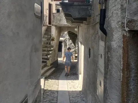 Vicolo stretto e lastricato tra le case di un borgo