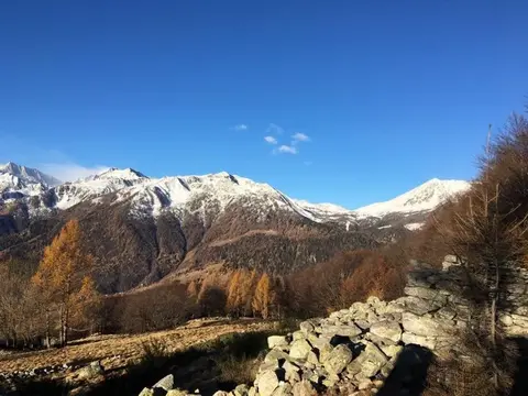 Le montagne innevate e un muro a secco