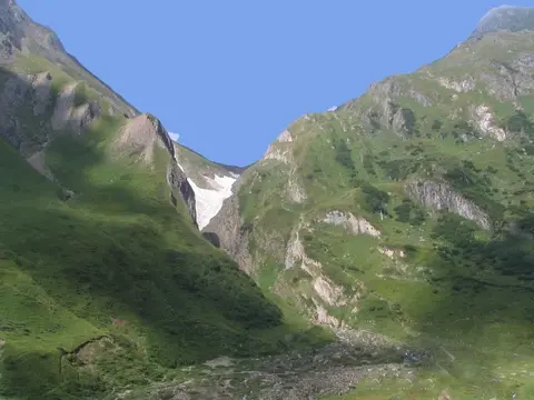 Il sentiero per il Sabbione sale nella conca erbosa, con una cascata sul fondo