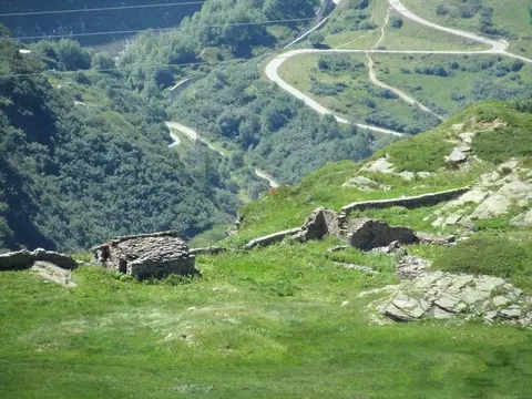 Le baite dell'alpe Ghighel e i tornanti della strada più in basso