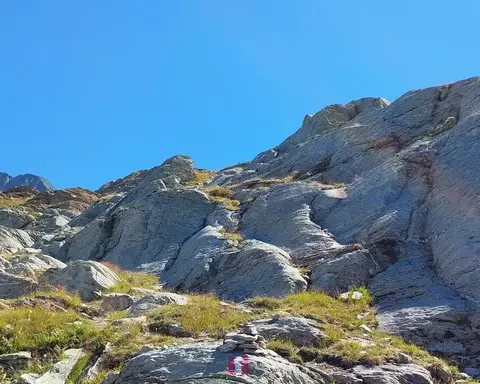 Rocce levigate dal ghiacciaio con i segni bianco-rossi del sentiero