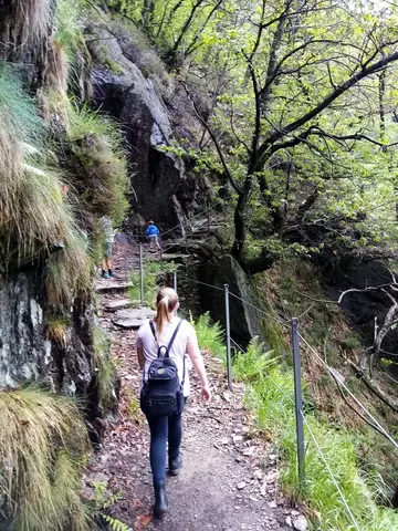 Un'escursionista sul sentiero scavato nella roccia verso Pogallo