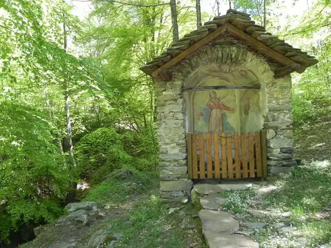 Una cappelletta in pietra con l'affresco nel bosco