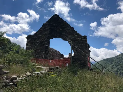 Il rudere di una baita con l'arco in pietra
