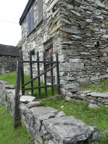 Una casa in pietra con il cancelletto di legno