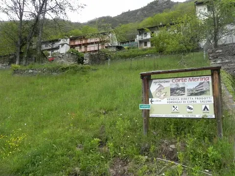 Il cartello dell'agriturismo Corte Merina sul prato