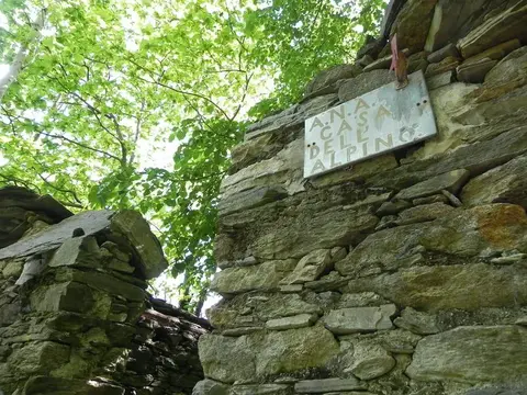 Una targa sul muro di una baita in pietra