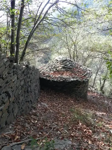 Un edificio in pietra con il tetto a cupola nel bosco