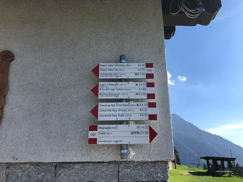 I cartelli sul muro di una baita ad Aleccio, con le indicazioni del sentiero G04