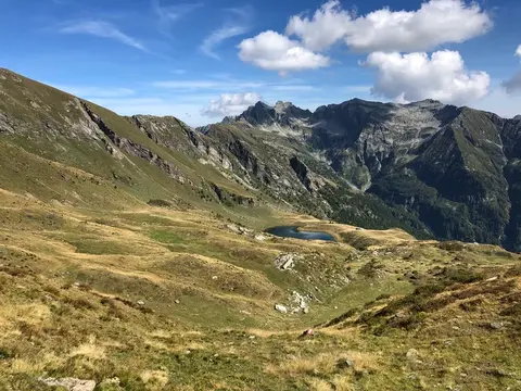 Il lago di Matogno tra i pascoli, sotto le montagne