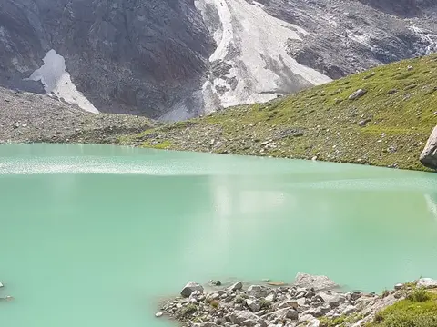 Le acque turchesi del lago delle Locce sotto il ghiacciaio