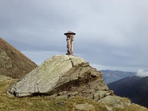 Una statua di legno su una roccia sopra la valle