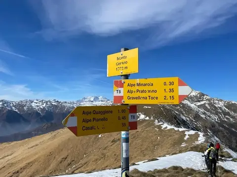 Il cartello di vetta del monte Cerano, con le montagne innevate sullo sfondo